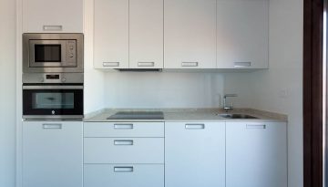 Cocina en blanco amueblada en dos frentes en León en una buhardilla